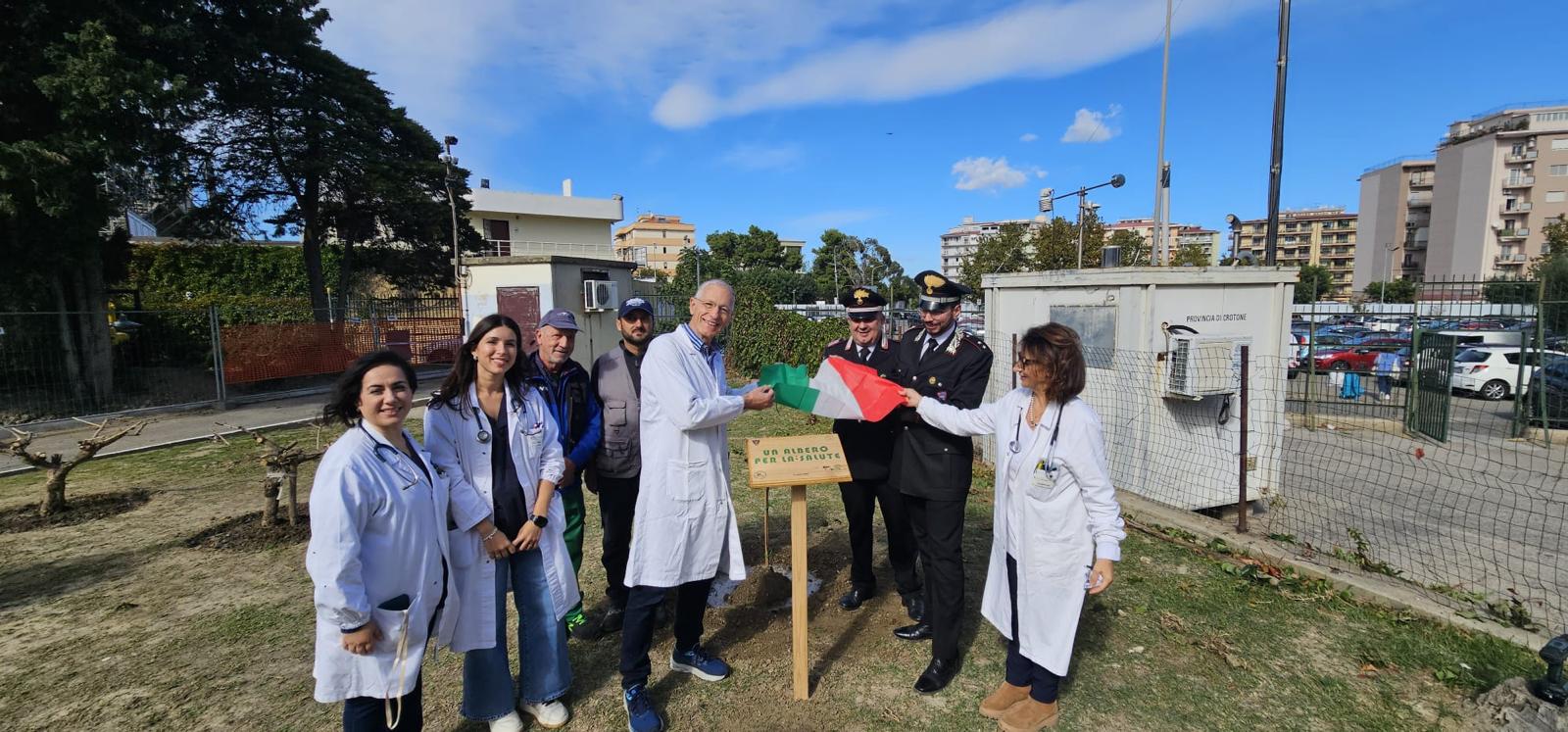 Un albero per la salute: partecipanti con tricolore e cartello dell’iniziativa